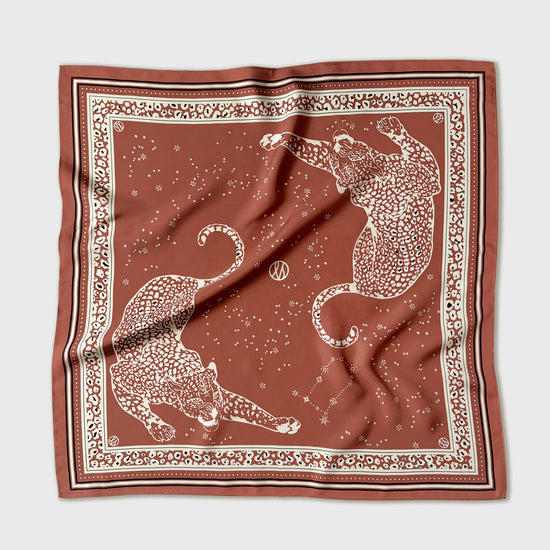 Brown scarf with white animal pattern on a light gray background