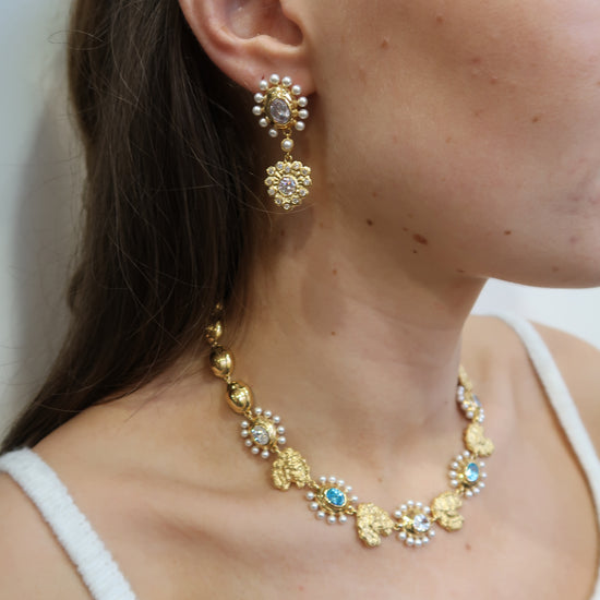 Gold necklace with pearls and blue stones and matching earrings model shot