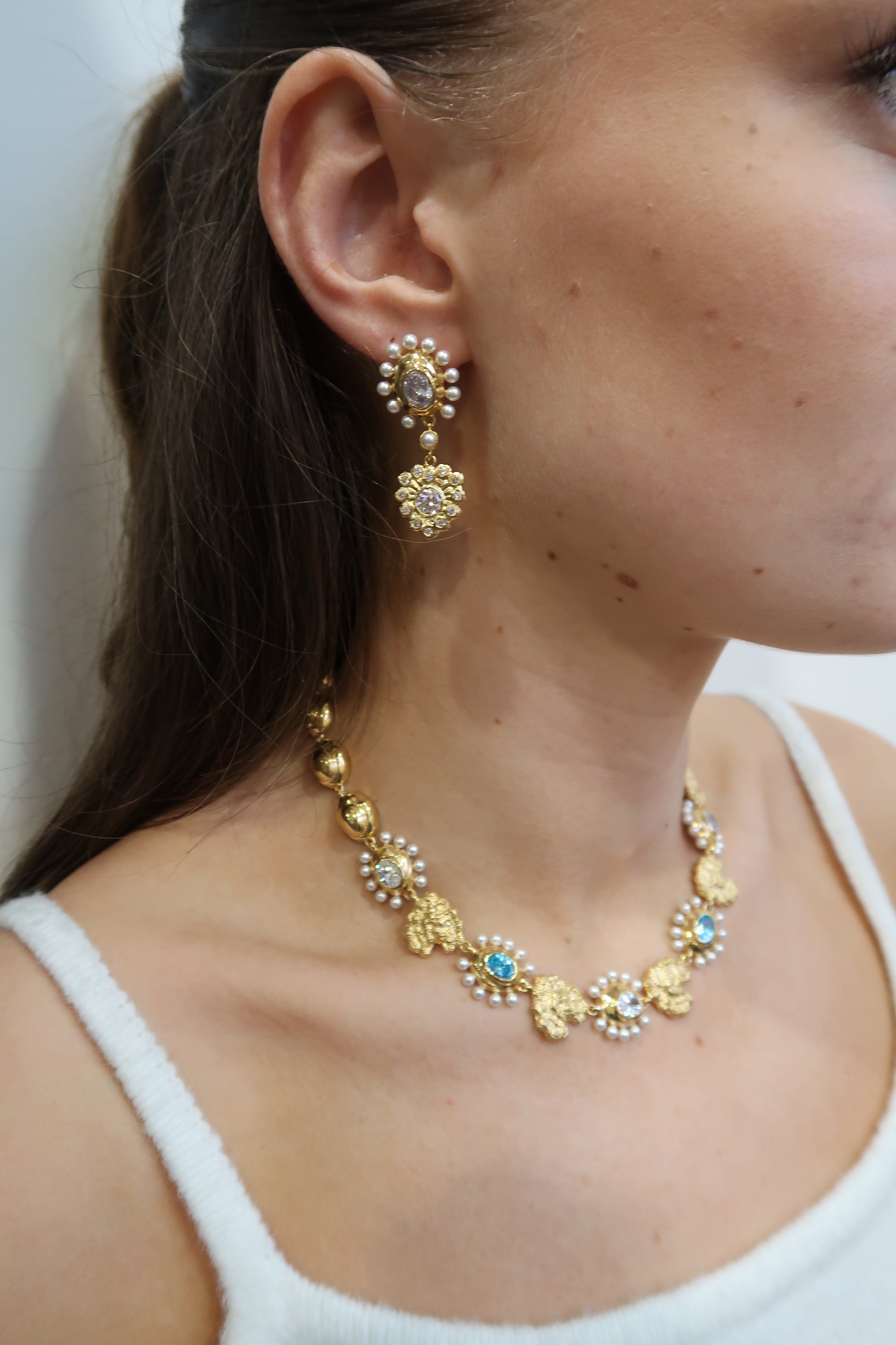 Gold necklace with pearls and blue stones and matching earrings model shot