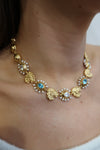 Gold necklace with pearls and blue stones on models neck