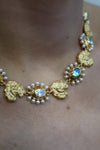 Gold necklace with pearls and blue stones and matching earrings model shot close up