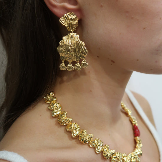 gold petal earrings with larger petal and small charm drops model shot