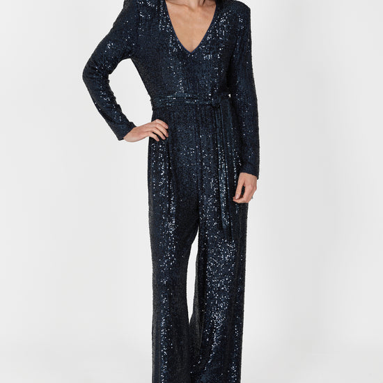 navy sequin jumpsuit with v neck, long sleeves and shoulder pads