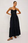 Woman wearing a black dress with gold accents on a white background
