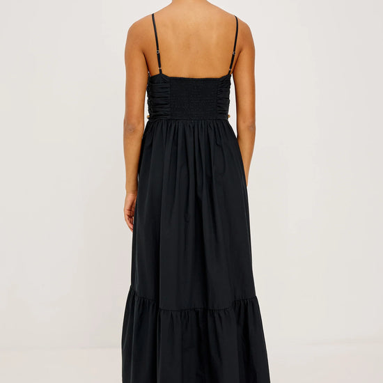 Woman wearing a black dress with thin straps on a white background