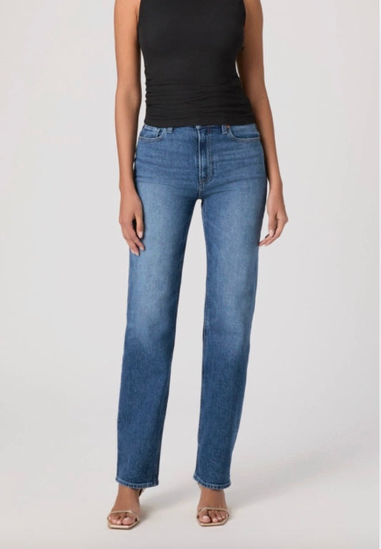 Person wearing blue jeans and a black top on a white background