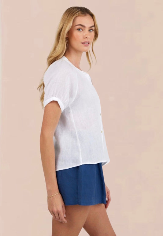 Woman wearing a white blouse and blue shorts on a beige background