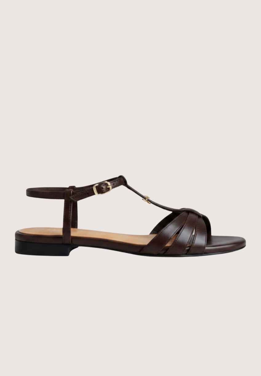 Brown sandal with a thin strap on a light gray background
