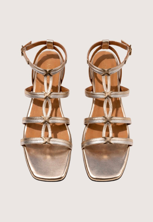 Pair of metallic sandals on a light gray background