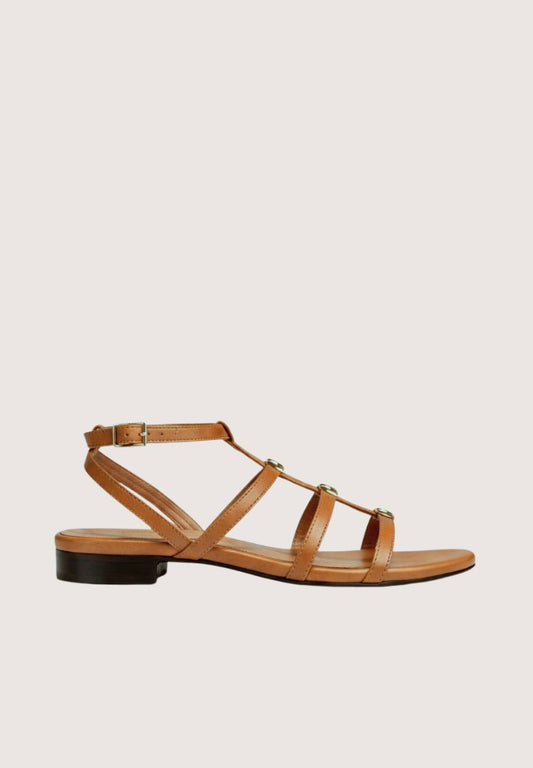 Tan sandal with thin straps on a light beige background