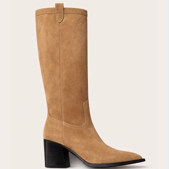 Tan knee-high  cow boy boot with a black block heel on a light beige background
