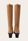 Tan knee-high  cow boy boot with a black block heel on a light beige background