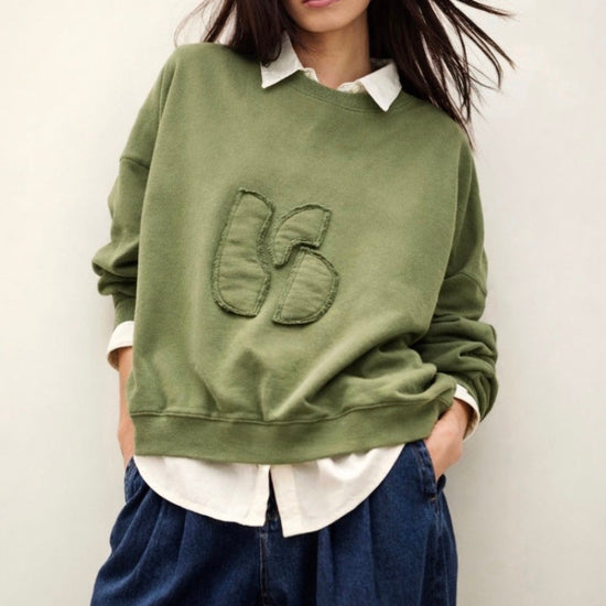 stylish slouchy forest green sweatshirt with bash detail on the front 