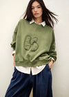stylish slouchy forest green sweatshirt with bash detail on the front 