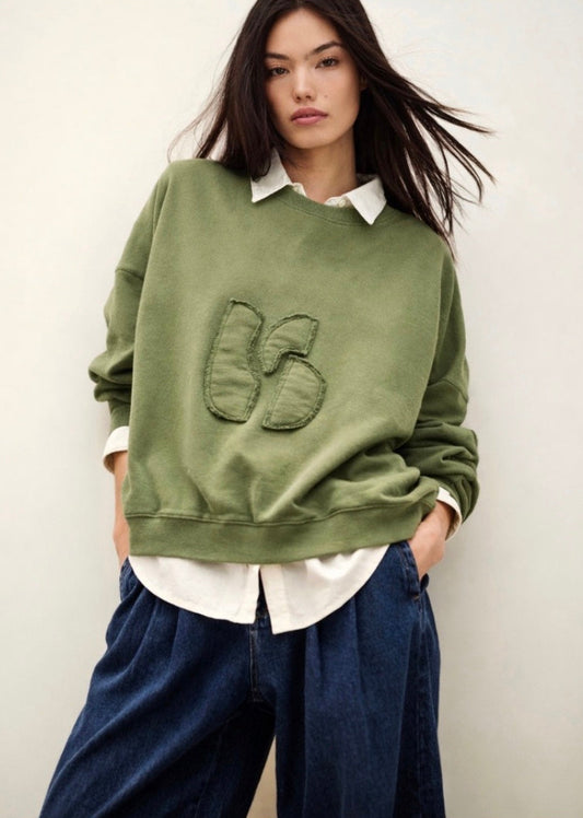 stylish slouchy forest green sweatshirt with bash detail on the front 