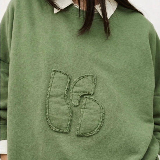 stylish slouchy forest green sweatshirt with bash detail on the front 