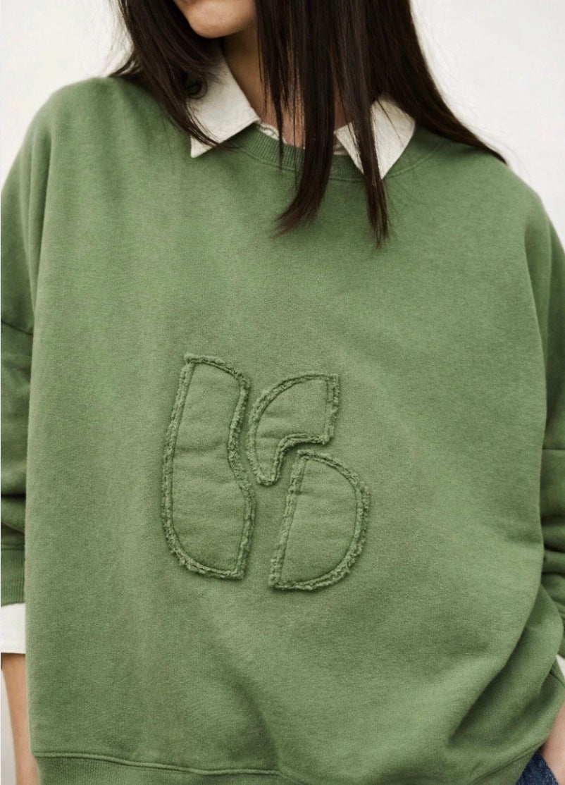 stylish slouchy forest green sweatshirt with bash detail on the front 