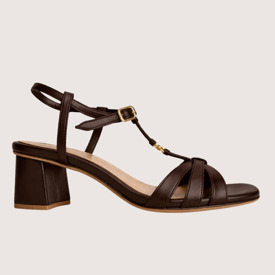 Brown leather sandal with a block heel on a light gray background