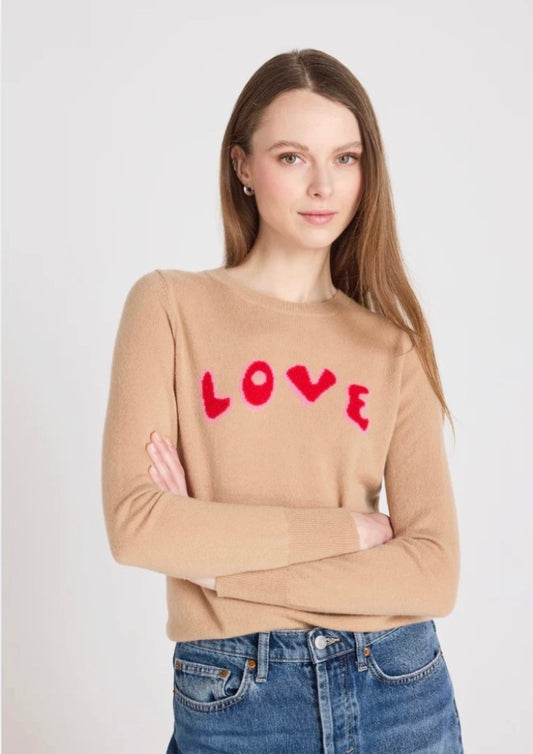 Woman wearing a beige sweater with 'LOVE' printed in red on a white background