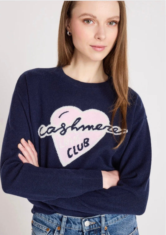 Close up model shot wearing a navy jumper with slogan on it on a white background 