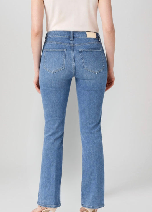 Blue jeans worn by a person on a plain background