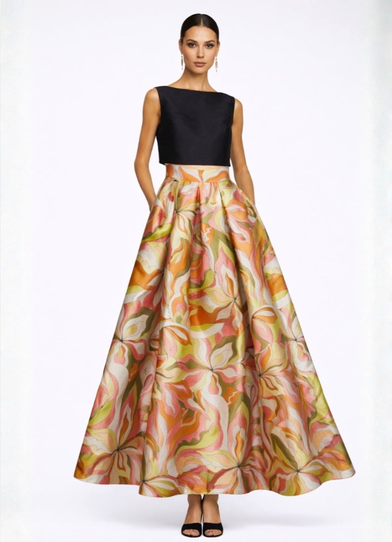 Woman wearing a black top and floral skirt on a white background