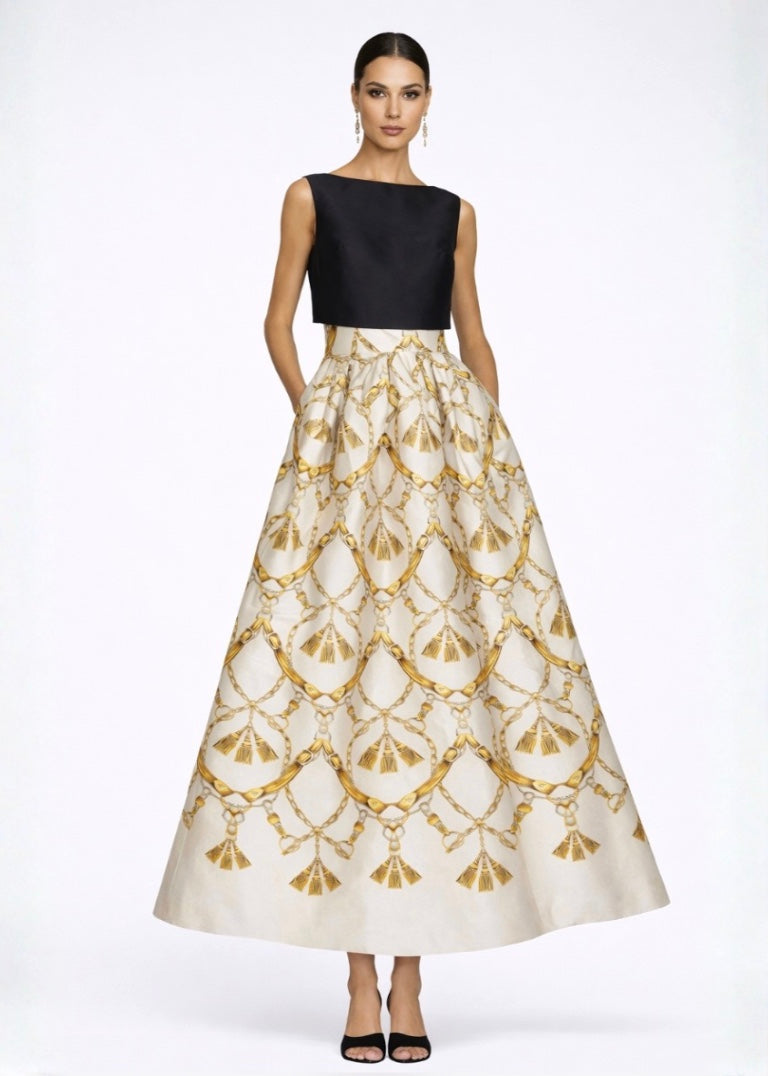 Woman wearing a black top and gold-patterned white skirt on a white background