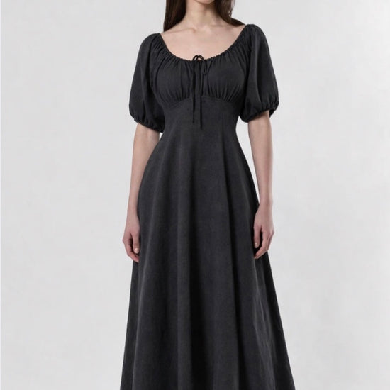 Woman wearing a black dress with puff sleeves on a white background