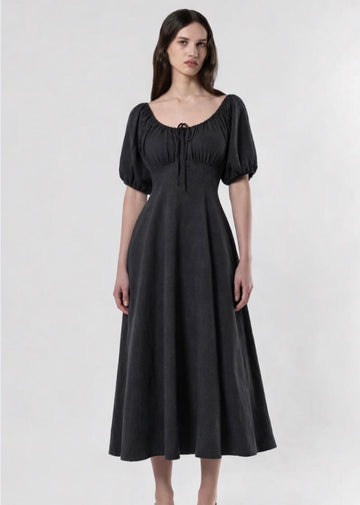 Woman wearing a black dress with puff sleeves on a white background