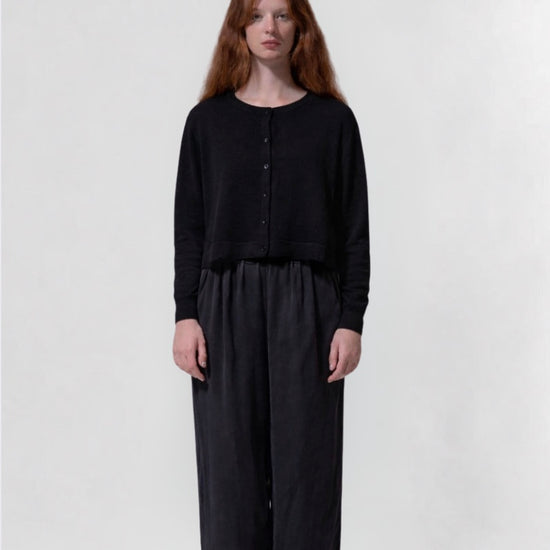 model shot wearing a black cropped boxy cardigan