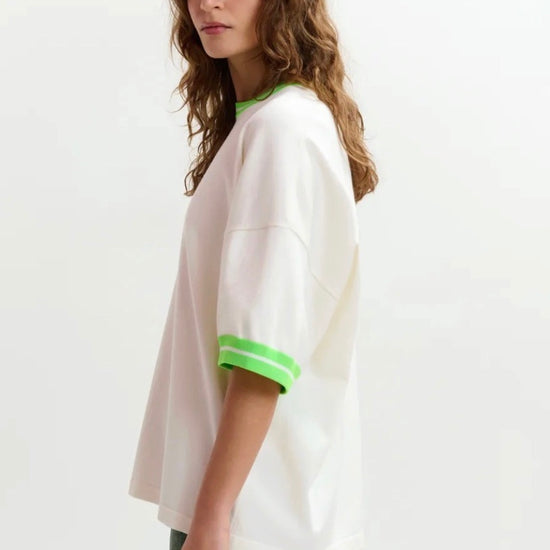 White t-shirt with green trim on a white background