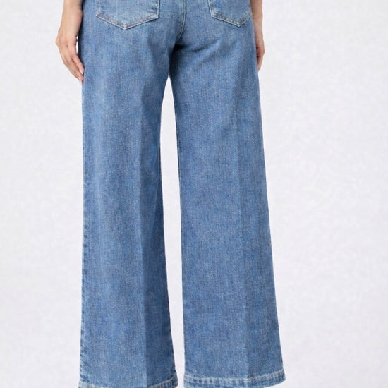 Person wearing light blue wide-leg jeans on a white background