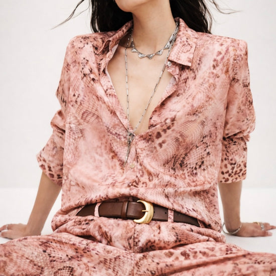 Woman wearing a pink animal print outfit with a belt from ba&sh