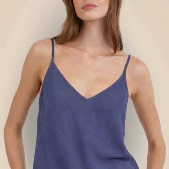 Woman wearing a blue tank top against a plain background