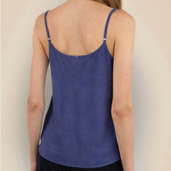 Person wearing a blue tank top against a plain background