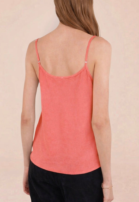 Woman wearing a coral tank top against a plain background