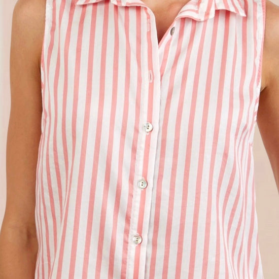 Woman wearing a sleeveless pink and white striped shirt against a beige background