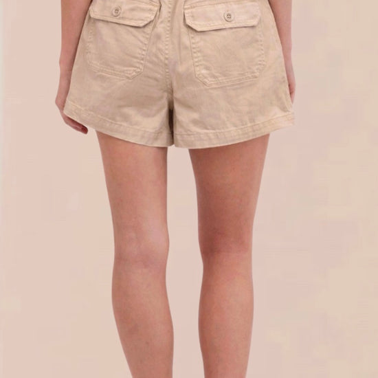 Beige shorts worn by a person on a beige background