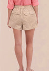 Beige shorts worn by a person on a beige background