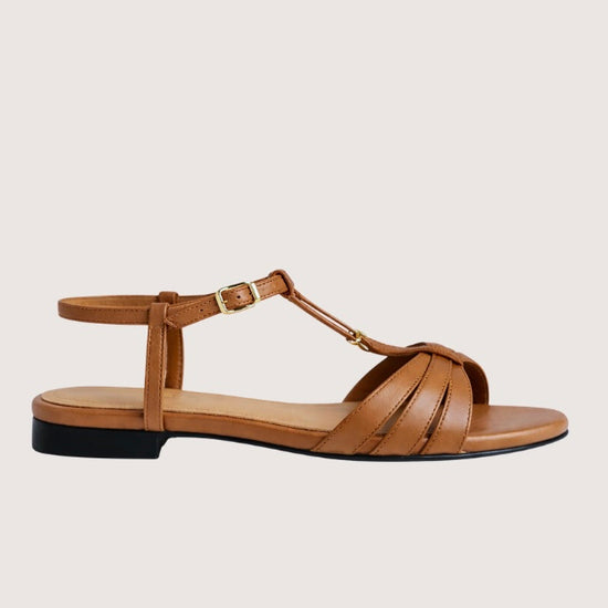 Brown sandal with a black sole on a light gray background