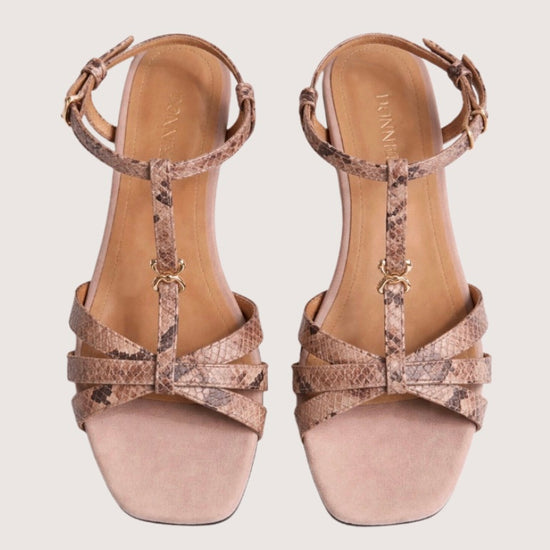 Pair of beige high-heeled sandals with metallic accents on a light gray background