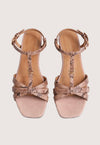 Pair of beige high-heeled sandals with metallic accents on a light gray background