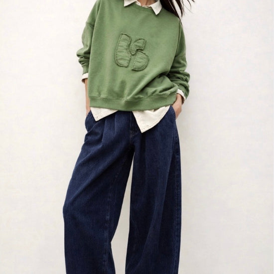 stylish slouchy forest green sweatshirt with bash detail on the front 