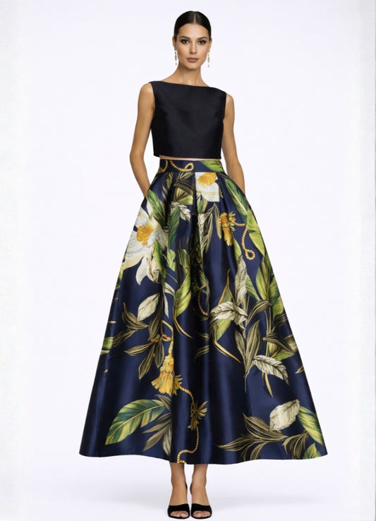 Woman wearing a black top and floral skirt on a white background