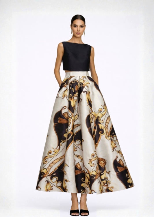 Woman wearing a black top and a long, patterned skirt on a white background