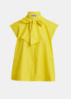 Yellow blouse with a large bow on a white background