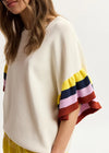 Beige sweater with colorful sleeves on a white background