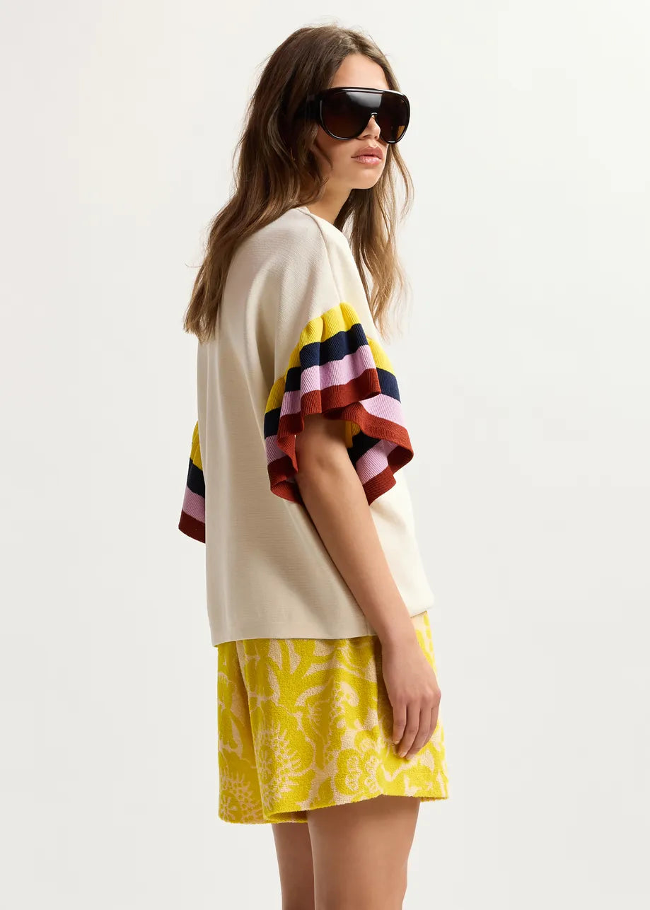 Woman wearing a colorful striped top and yellow skirt on a white background