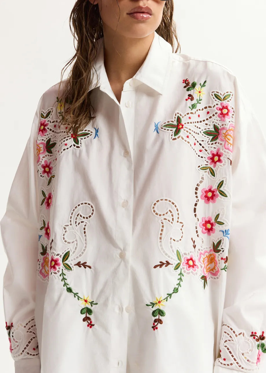 White shirt with colorful floral embroidery on a white background