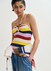 Woman wearing a colorful striped top and blue pants on a white background